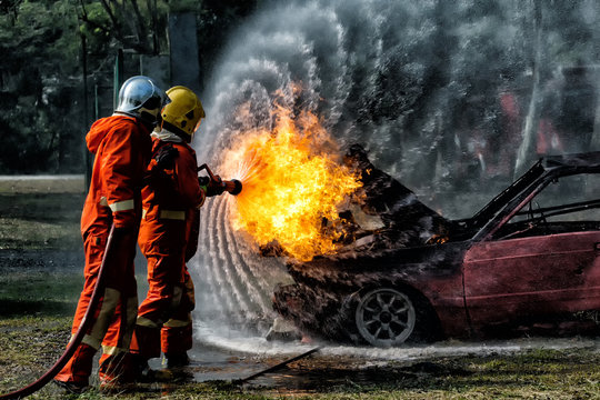 Firefighter training, Fireman annual training fire fighting hosing water to extinguish a fire over the accident car  on the wayside road