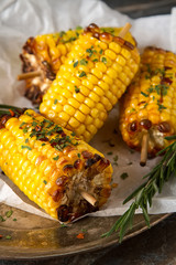 Corn grilled with salt and spices. Dark background. Fast food in the summer.