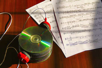 Stack of CDs with headphone and musical notes