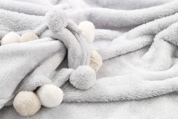 Grey blanket with pompoms.