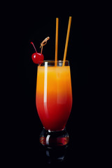Glass of Sex on the Beach cocktail against black background