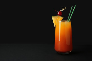 Glass of Sex on the Beach cocktail against dark background