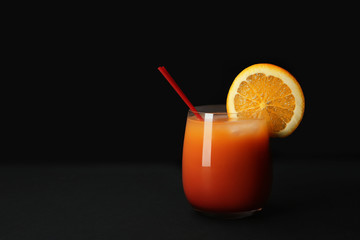 Glass of Sex on the Beach cocktail against dark background