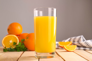 Glass of fresh orange juice on wooden table