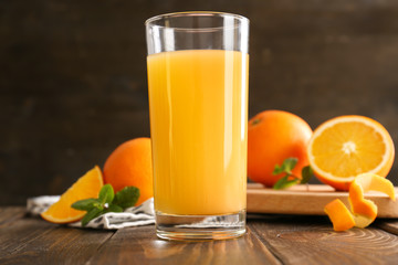 Glass of fresh orange juice on wooden table
