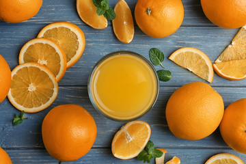 Beautiful composition with fresh orange juice and fruit on wooden table, top view