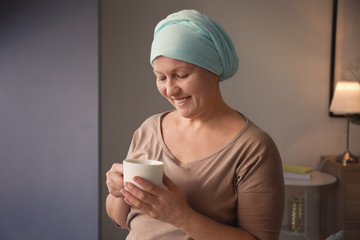 Mature woman with cancer drinking tea indoors
