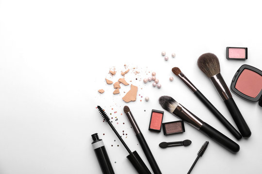 Decorative cosmetics and tools of professional makeup artist on white background