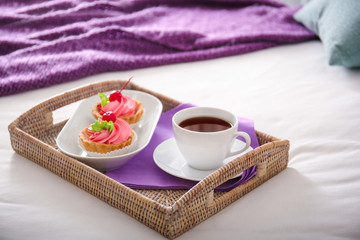 Obraz na płótnie Canvas Tray with tasty breakfast on comfortable bed at home