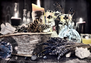 Antique witch book with lavender flowers, magic ritual objects, healing herbs, crystal and black...