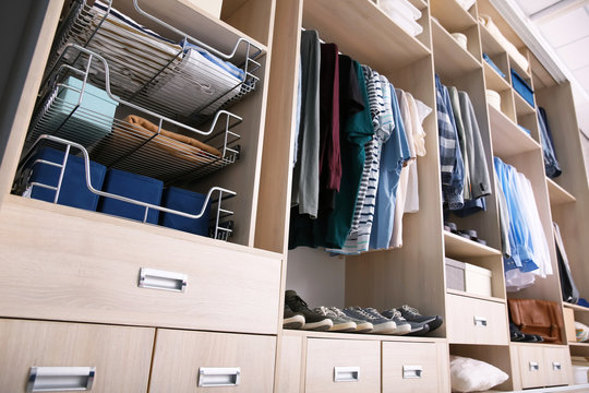 Big wardrobe with male clothes for dressing room
