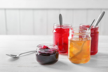 Jars with sweet jams on table