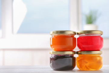 Jars with sweet jams on table