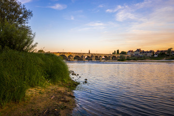Fototapeta premium Sunset over the Loire river at La Charité-sur-Loire, Central France, with the Pont La Loire bridge in the background
