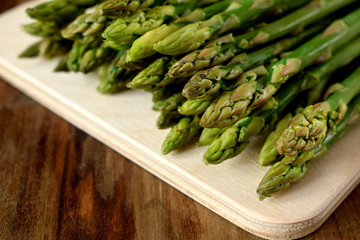 Green asparagus stalks on a wooden board