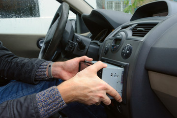 Man removing audio system from car dashboard. Automobile audio receiver disconnecting and removing