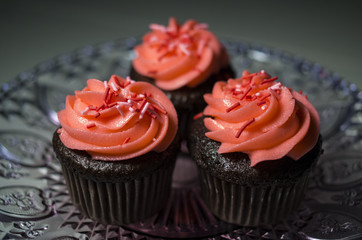 Colorfully decorated cupcakes on a decorative cake tray.