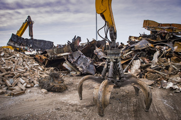 Large tracked excavator working a steel pile at a metal recycle yard