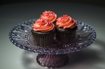 Colorfully decorated cupcakes on a decorative cake tray.