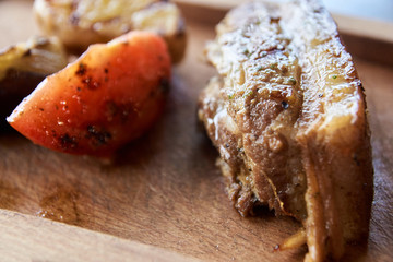 Slice red tomato. Grilled meat. Brown background