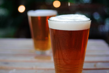 Beer on wood table in garden background. Selective focus