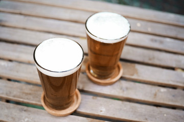 Beer on wood table in garden background. Selective focus
