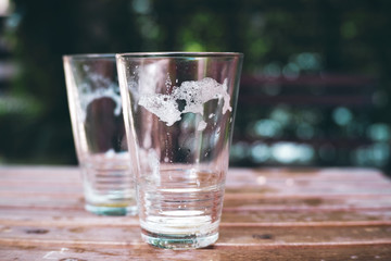 Empty beer glass on garden background.