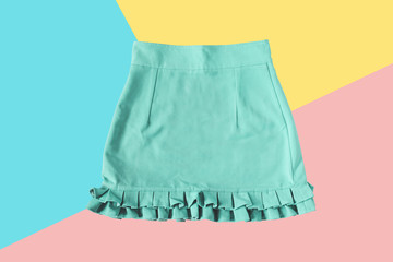 Green mini skirt on pink, yellow and blue background. fashion minimal. pastel