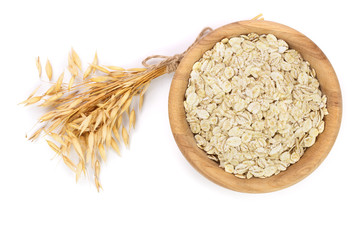 oat spike with oat flakes in wooden bowl isolated on white background