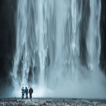Tourist under the waterfall in Iceland, Adventure photo, edit space