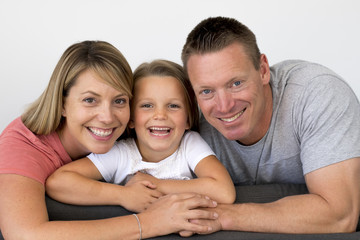 young beautiful and happy Caucasian couple with mother and father posing cheerful together with adorable 7 years old blond little girl