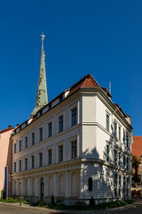 Schlichte Eleganz: denkmalgeschütztes Eckhaus im Berliner Nikolaiviertel, dahinter die Turmspitze...