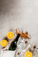 Christmas hot drinks recipes, Set of ingredients for mulled wine: wine bottle, glass cups, spices, orange. Gray stone background, copy space top view