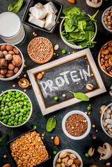 Healthy diet vegan food, veggie protein sources: Tofu, vegan milk, beans, lentils, nuts, soy milk, spinach and seeds. Top view on white table.