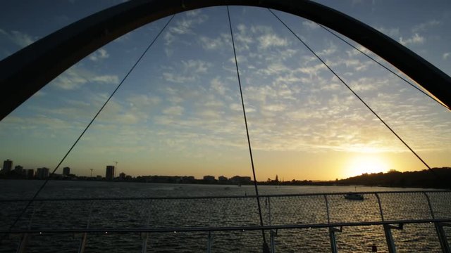 Scenic and iconic Elizabeth Quay Bridge at sunset light on Swan River at entrance of Elizabeth Quay marina. The arched pedestrian bridge is a new tourist attraction in Perth, Western Australia.