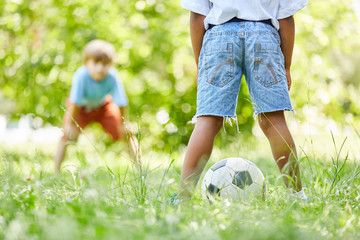 Zwei Kinder spielen Fußball zusammen
