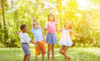 Fototapeta premium Gruppe Kinder beim Jubeln und Tanzen im Sommer