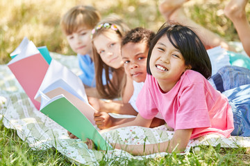 Kinder machen Hausaufgaben in freier Natur