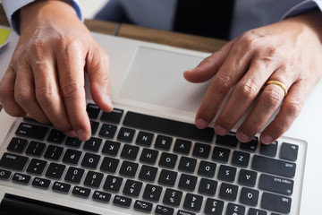 Business man working at office with laptop, tablet and graph data documents on his desk