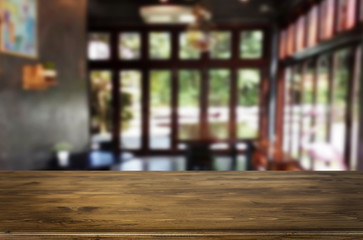 Selected focus empty brown wooden table and Coffee shop or restaurant blur background with bokeh image. for your photomontage or product display.