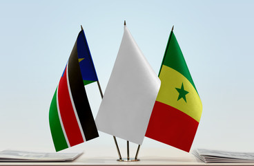 Flags of South Sudan and Senegal with a white flag in the middle