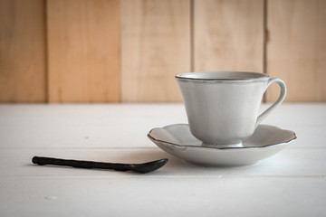 Tea set is Gray on a wooden background. Teapot, creamer, Cup and saucer on the table. Ceramic...