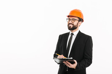 Happy engineer businessman in helmet writing notes.