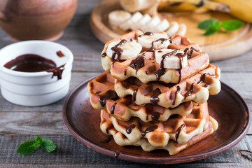 Homemade Belgian waffles with chocolate sauce and banana slice on a plate
