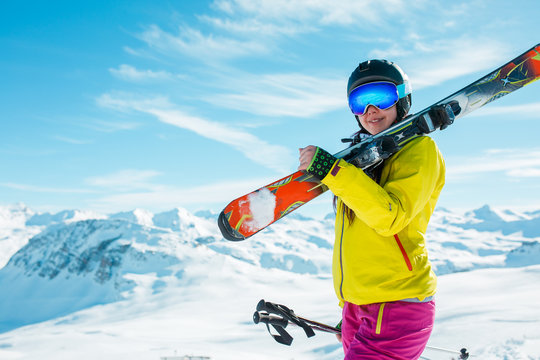 Image of girl wearing helmet, mask with skis on her shoulder