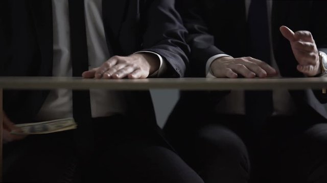 Politician hands taking bribe money under office table, lobbying of interests