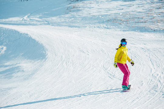 Image of sports woman snowboarding from mountain slope