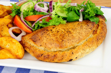 Pasty and potato wedges meal with fresh salad isolated on a white background