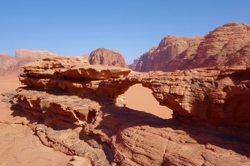 Fototapeta na wymiar Natural rock bridge and panoramic view of Jordanian desert Wadi Rum