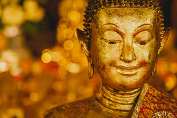 Smile of the golden Buddha, Face of gold buddha With bokeh background, Thailand, Asia,